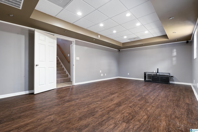 unfurnished living room featuring a raised ceiling and dark hardwood / wood-style floors