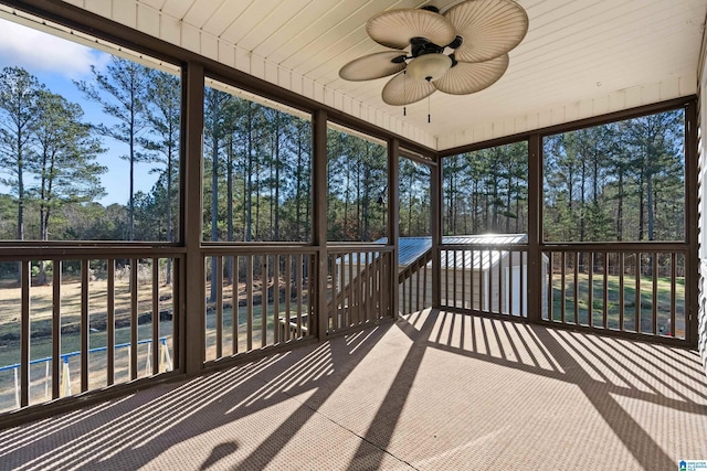 unfurnished sunroom featuring ceiling fan