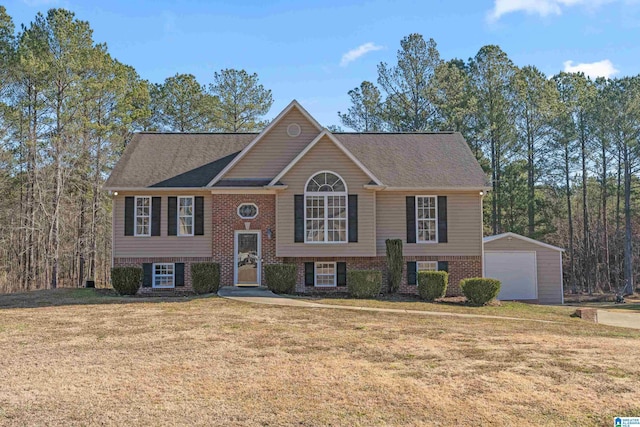 split foyer home featuring a garage, a front yard, and an outbuilding