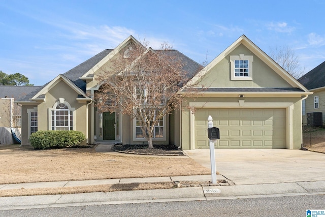 view of property with a garage and central air condition unit