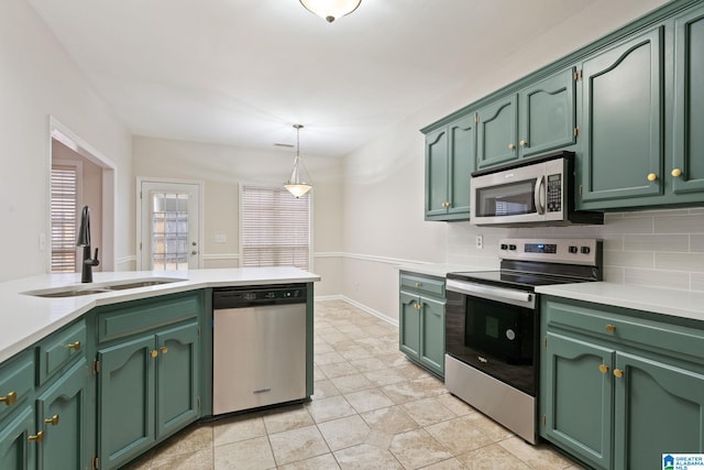 kitchen featuring sink, stainless steel appliances, tasteful backsplash, and green cabinetry