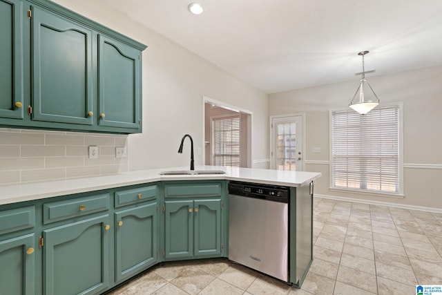 kitchen featuring stainless steel dishwasher, green cabinets, sink, and hanging light fixtures