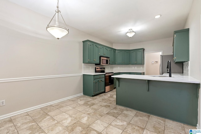 kitchen with sink, green cabinets, kitchen peninsula, decorative backsplash, and appliances with stainless steel finishes