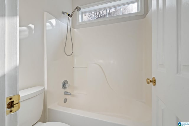 bathroom featuring toilet and bathing tub / shower combination