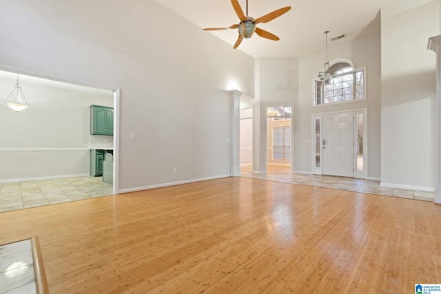 entrance foyer featuring ceiling fan, a high ceiling, and light hardwood / wood-style flooring