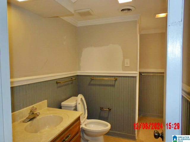 bathroom featuring vanity, toilet, and crown molding