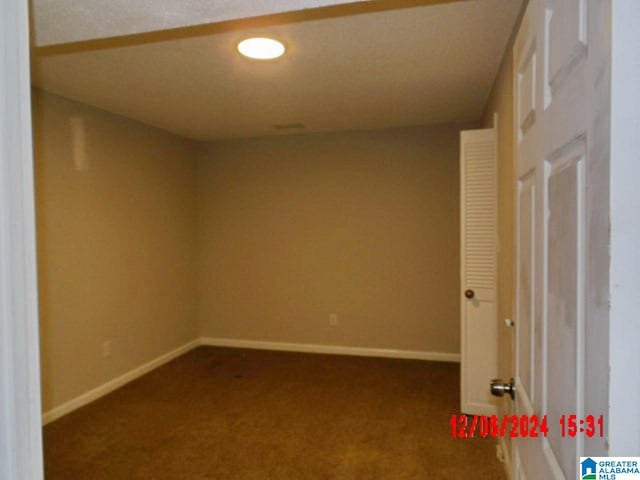 unfurnished room with dark carpet