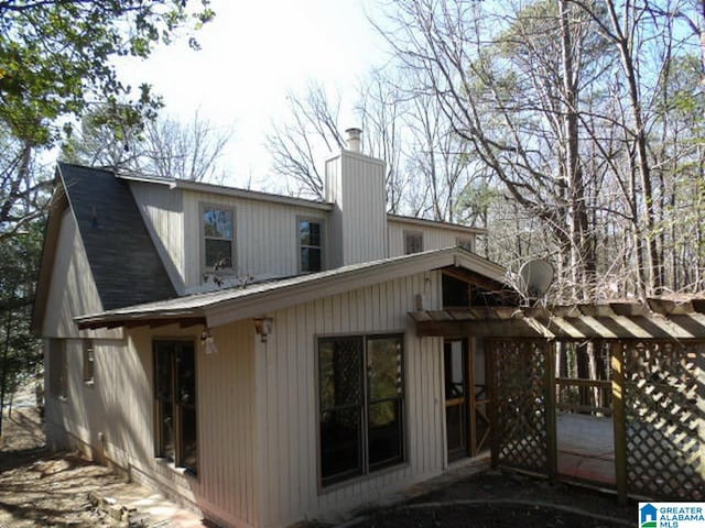 rear view of property featuring a pergola