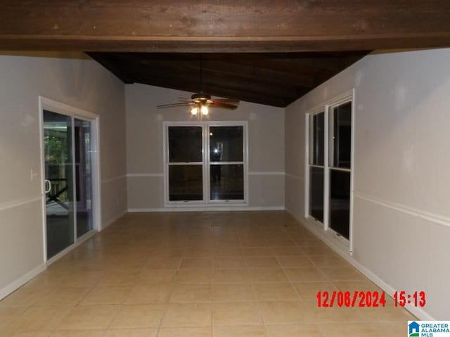 interior space with vaulted ceiling with beams, ceiling fan, and light tile patterned flooring