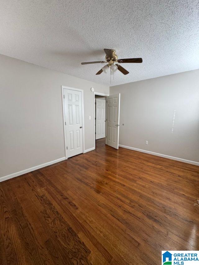 unfurnished bedroom featuring a textured ceiling, dark hardwood / wood-style floors, and ceiling fan