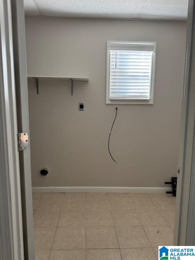 washroom featuring electric dryer hookup and light tile patterned floors