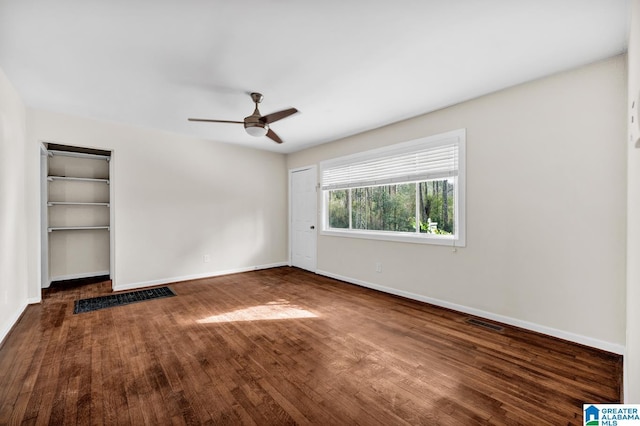 spare room featuring ceiling fan and dark wood-type flooring