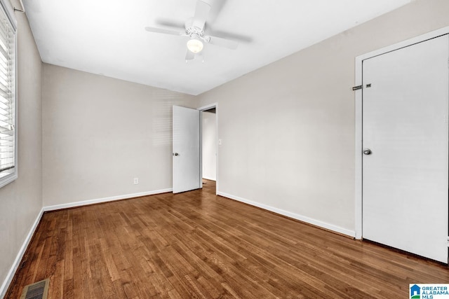 unfurnished bedroom with multiple windows, ceiling fan, and hardwood / wood-style floors