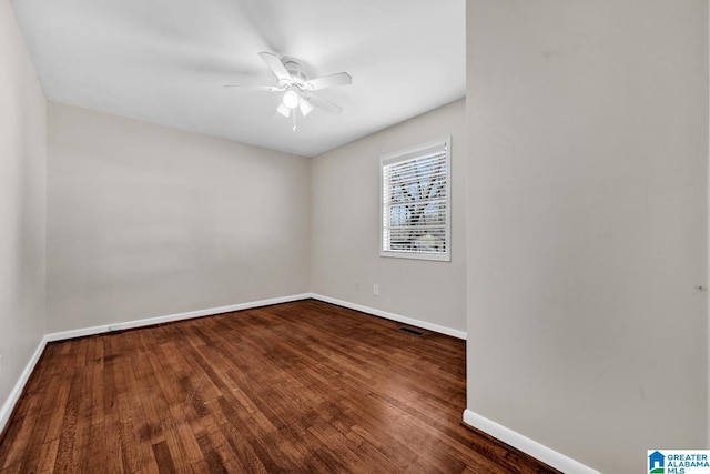 spare room with dark hardwood / wood-style flooring and ceiling fan