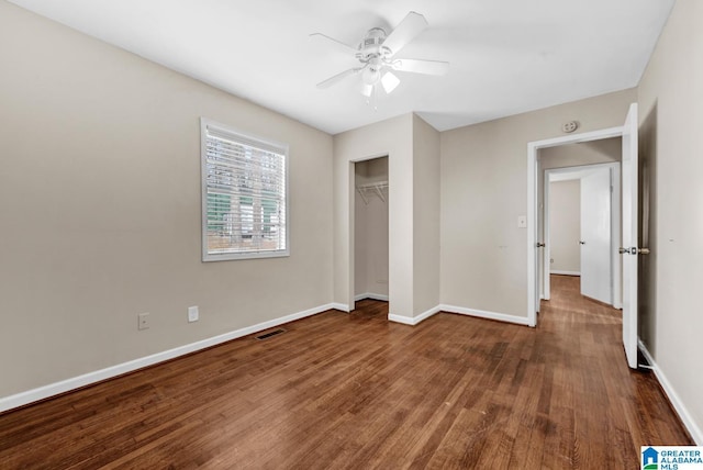 unfurnished bedroom with ceiling fan, a closet, and dark wood-type flooring