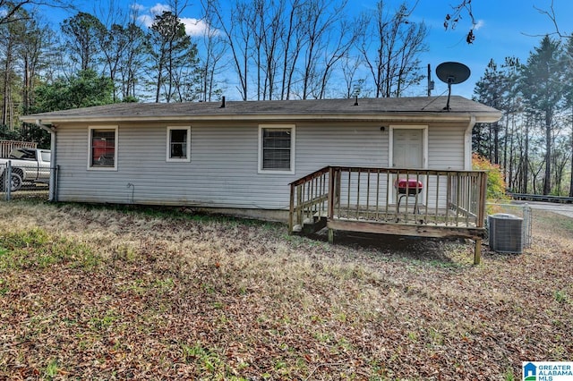 rear view of house with central AC unit and a wooden deck