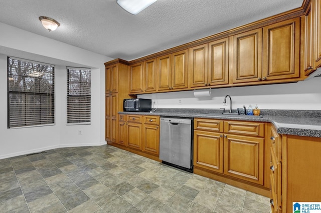 kitchen with a textured ceiling, stainless steel dishwasher, and sink