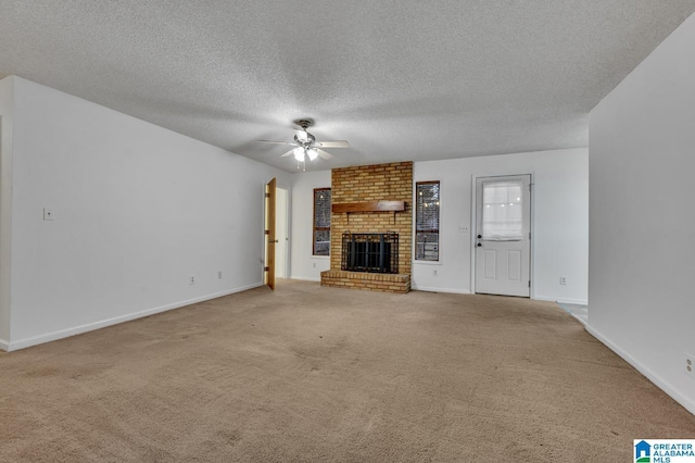 unfurnished living room featuring carpet, ceiling fan, a fireplace, and a textured ceiling