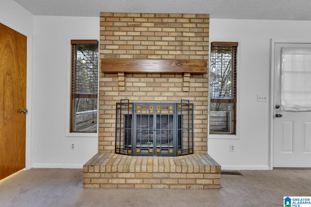 unfurnished living room with a textured ceiling, carpet floors, and a fireplace