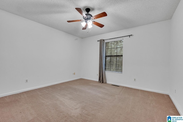 unfurnished room with a textured ceiling, ceiling fan, and light carpet