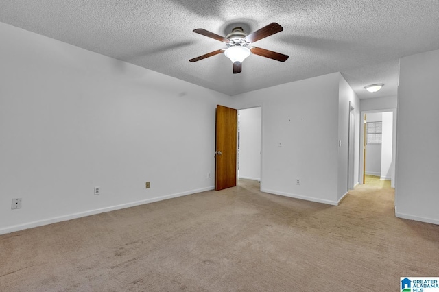 carpeted empty room with ceiling fan and a textured ceiling