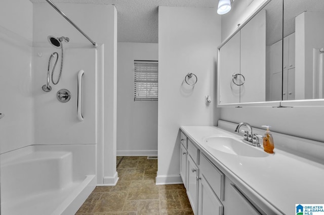 bathroom with a shower, a textured ceiling, and vanity