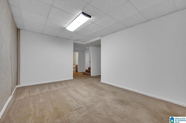 basement with light carpet and a paneled ceiling