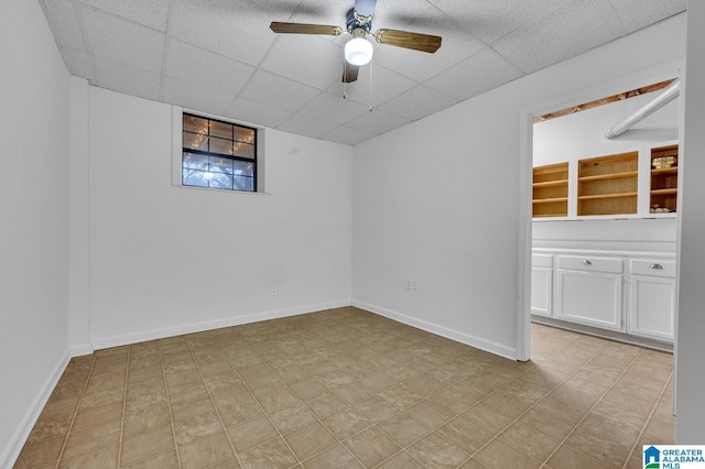 empty room featuring ceiling fan and a drop ceiling