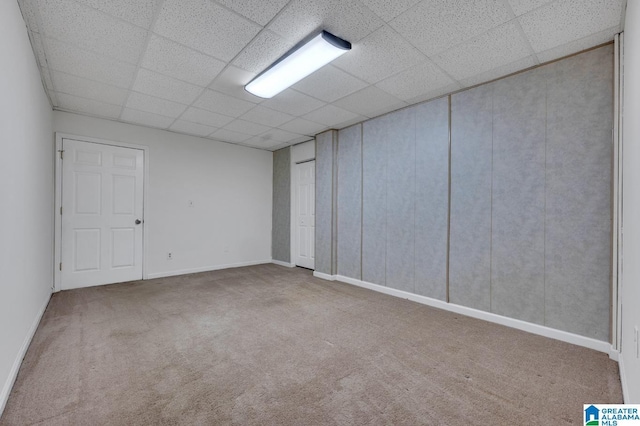 carpeted empty room with a drop ceiling