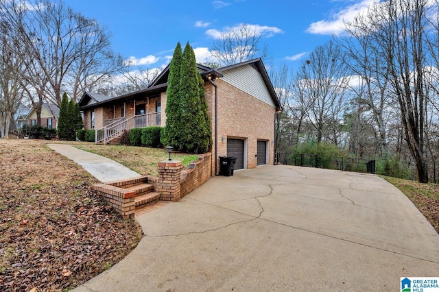 view of side of home with covered porch and a garage