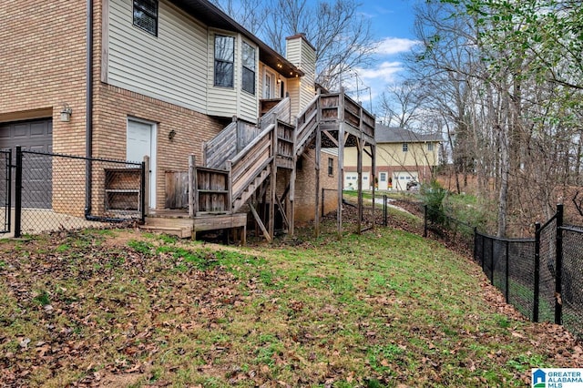 rear view of house with a garage and a wooden deck