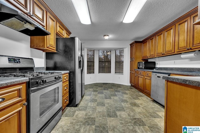 kitchen with a textured ceiling and appliances with stainless steel finishes