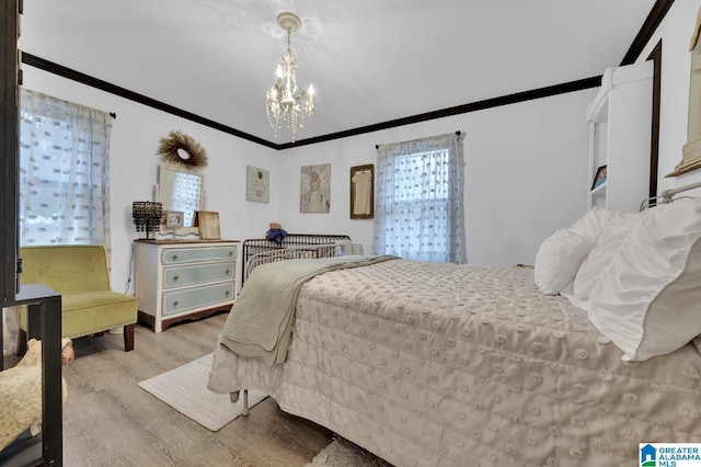 bedroom featuring a notable chandelier, light hardwood / wood-style floors, and ornamental molding