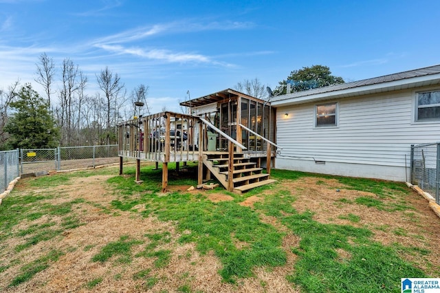 back of property featuring a sunroom, a deck, and a yard