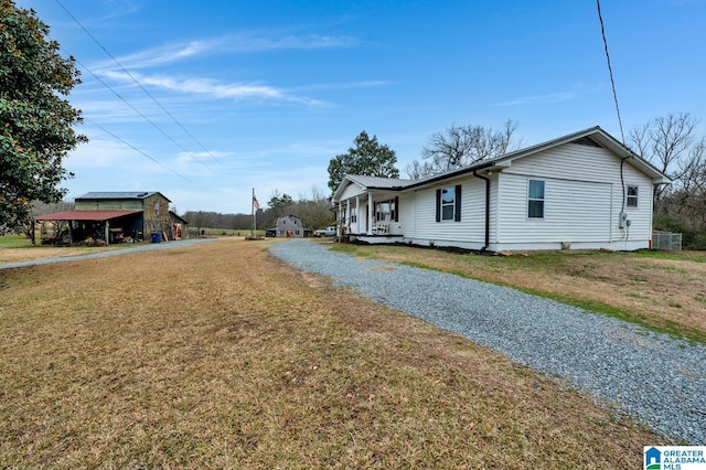 view of home's exterior with covered porch and a yard