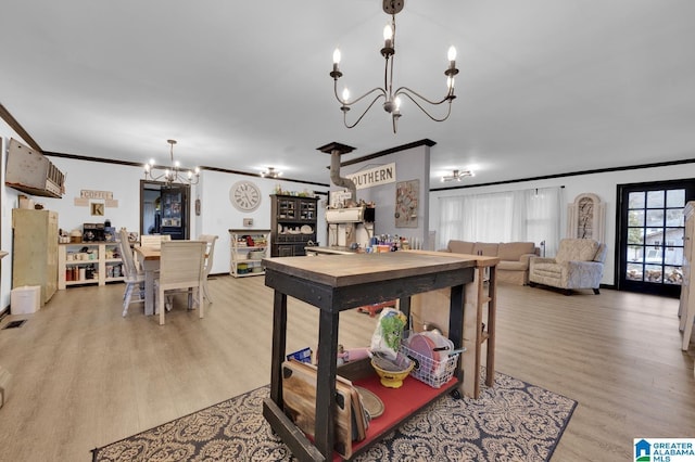 dining area featuring light hardwood / wood-style floors, ornamental molding, and a notable chandelier