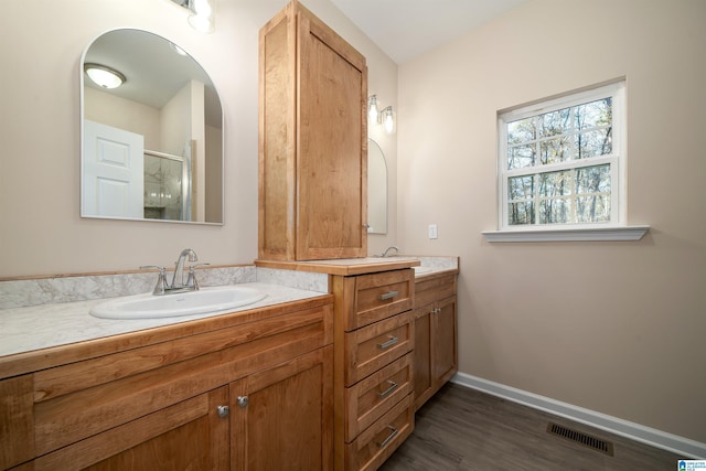 bathroom featuring a shower with shower door, vanity, and hardwood / wood-style floors