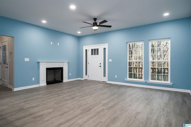 unfurnished living room featuring ceiling fan and wood-type flooring