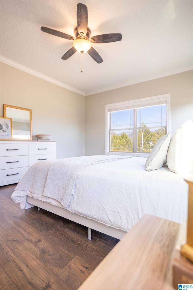 bedroom featuring dark hardwood / wood-style flooring, ceiling fan, and ornamental molding