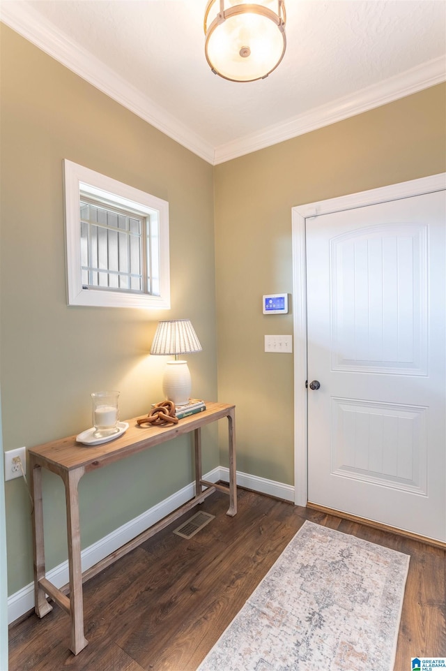 entryway with ornamental molding and dark wood-type flooring