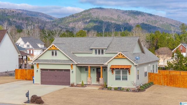 view of front facade featuring a mountain view, a garage, and cooling unit