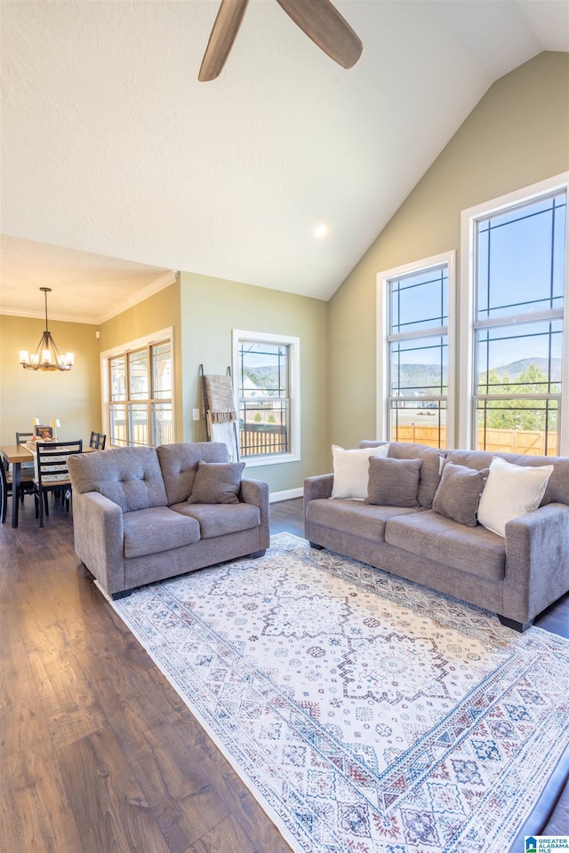 living room featuring wood-type flooring, ceiling fan with notable chandelier, and vaulted ceiling