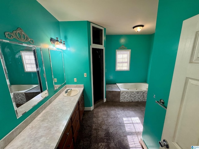 bathroom with a wealth of natural light, vanity, and tiled tub