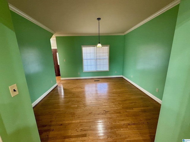 unfurnished dining area featuring crown molding and hardwood / wood-style floors