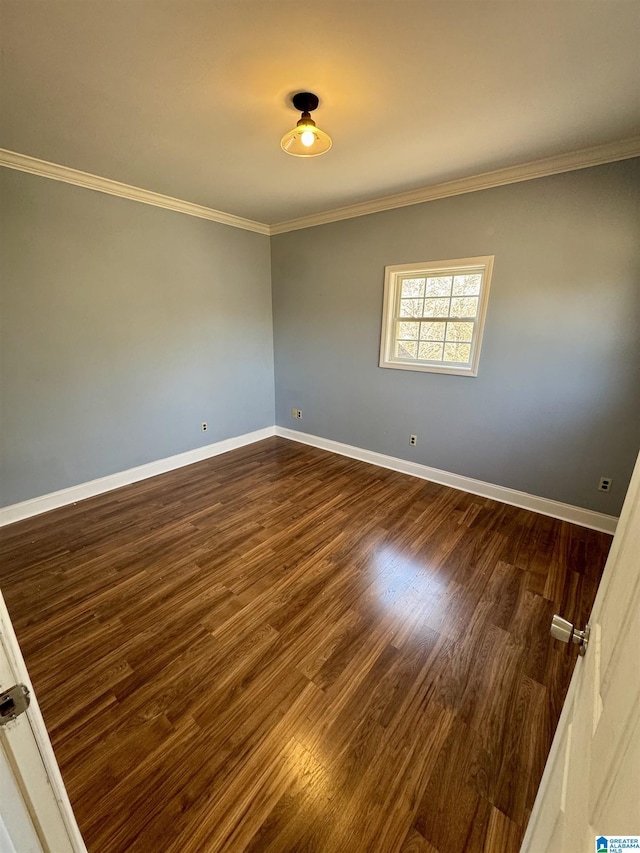 empty room with dark hardwood / wood-style flooring and ornamental molding