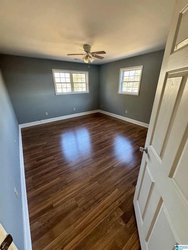 spare room with dark hardwood / wood-style flooring and ceiling fan