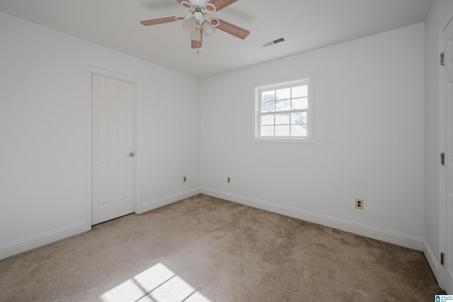 carpeted spare room featuring ceiling fan