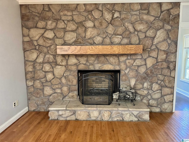 room details featuring hardwood / wood-style floors and a stone fireplace