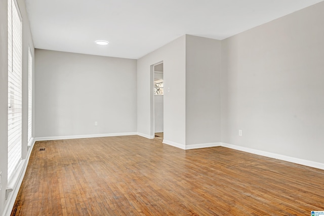 unfurnished room with wood-type flooring and a wealth of natural light