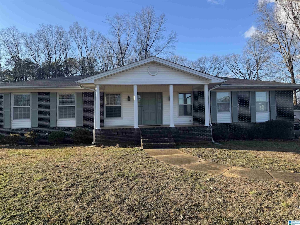 single story home with a porch and a front lawn